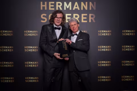 Bildunterschrift: Martin Blasl bekommt den Preis von Hermann Scherer überreicht